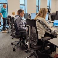 Kobiety i mężczyźni siedzący przed komputerami