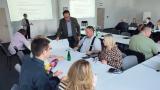 Dr inż. Piotr Manczarski przekazuje materiały jednej z grup warsztatowych, w tle dr inż. Anna Rolewicz-Kalińska i uczestnicy szkolenia